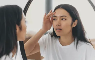 Woman analyzing facial anatomy to determine treatment plan with fillers and injectables